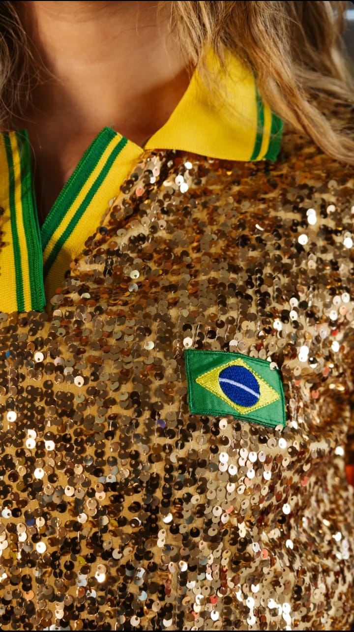 Close-up of gold sequin polo collar with yellow-green stripes and Brazilian flag patch, premium party knit for Brazilian diaspora